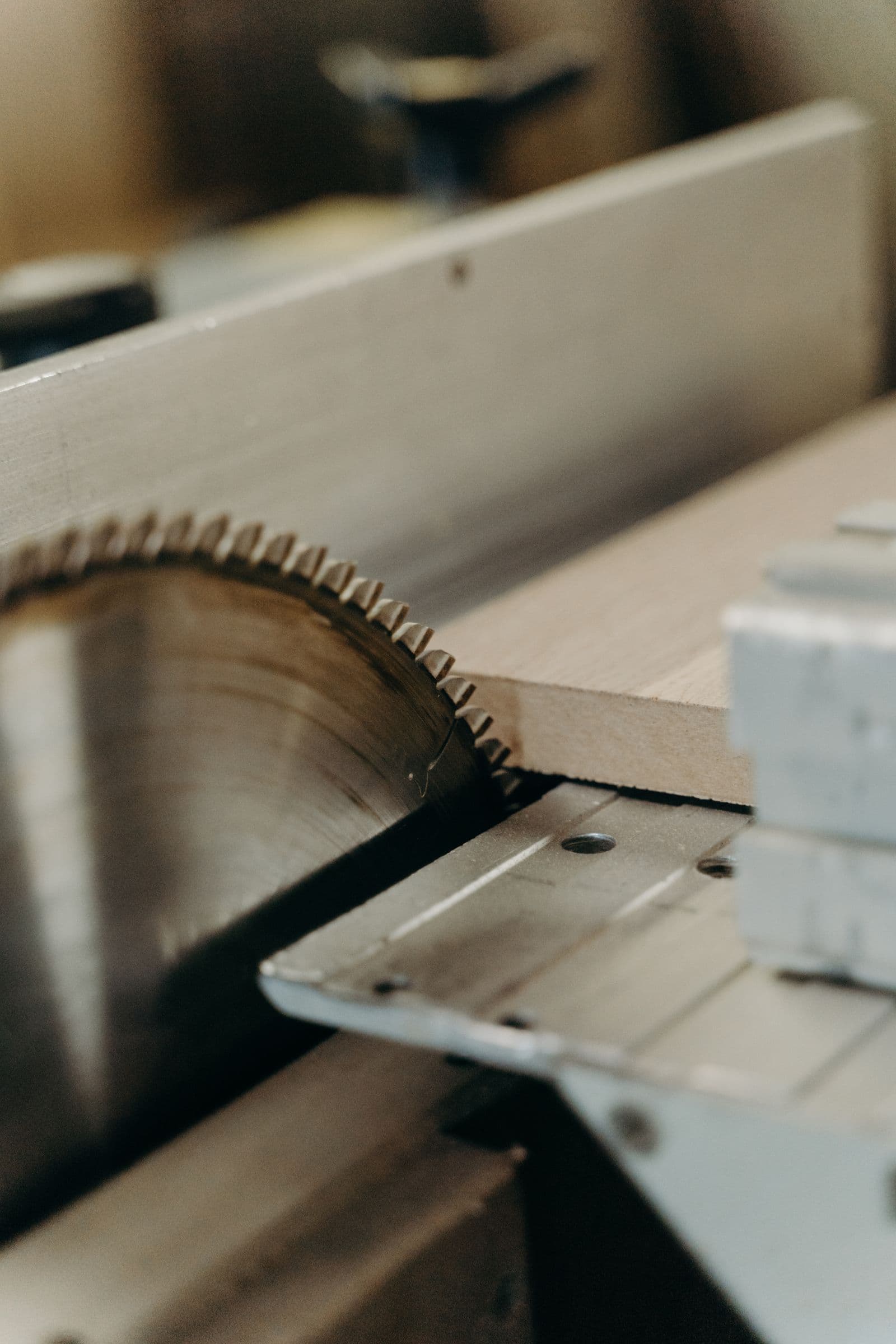 A saw blade cutting through a sheet on a table saw