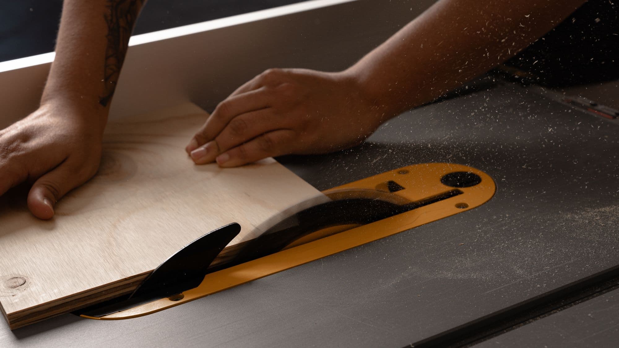 A sheet of material being guided through a table saw